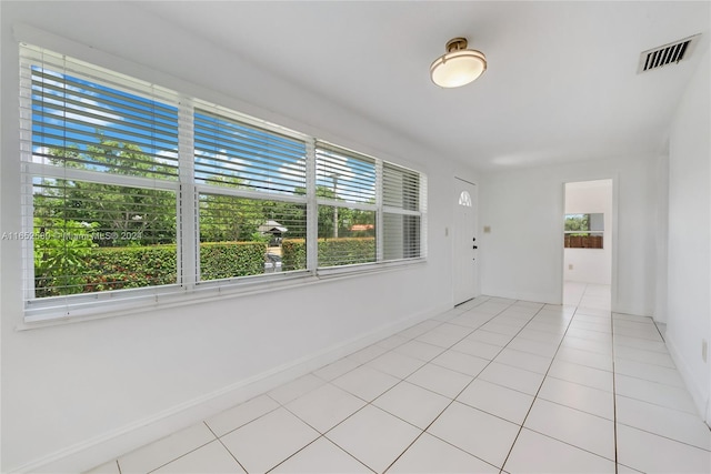 spare room with plenty of natural light and light tile patterned floors