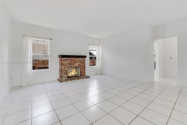 unfurnished living room with a healthy amount of sunlight, light tile patterned floors, and a fireplace