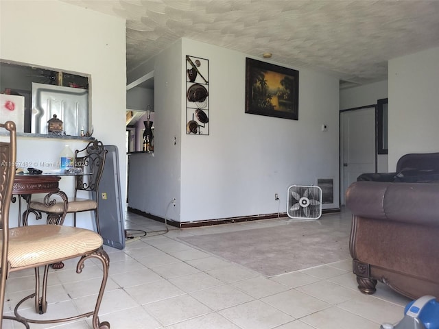 interior space with a textured ceiling and light tile patterned flooring