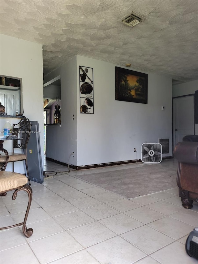 interior space with light tile patterned floors and a textured ceiling