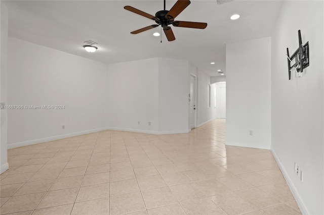 tiled empty room featuring ceiling fan