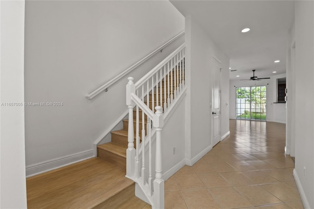 stairs with ceiling fan and tile patterned floors