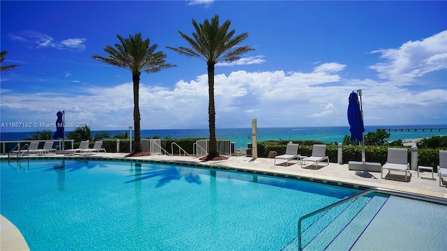 view of pool featuring a water view and a patio area