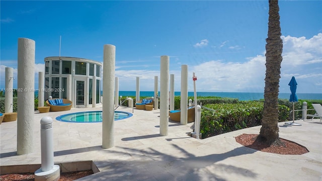 view of swimming pool with a water view and a patio