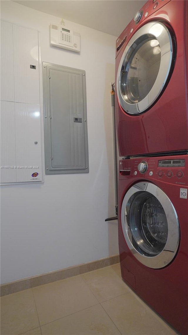 washroom with electric panel, stacked washer and dryer, and tile patterned floors