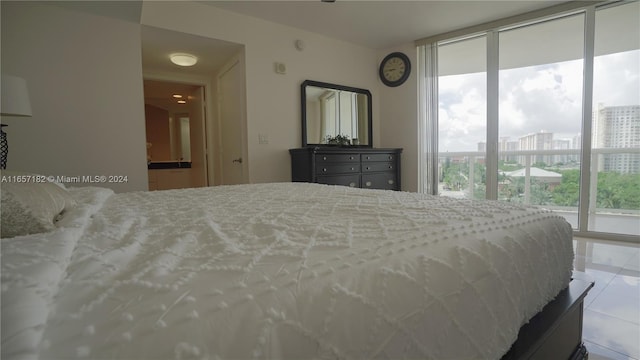 bedroom featuring tile patterned flooring and a wall of windows