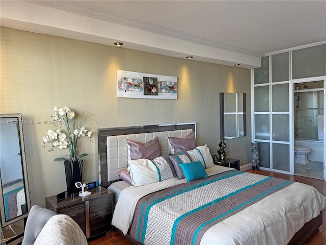 bedroom with connected bathroom and dark hardwood / wood-style floors