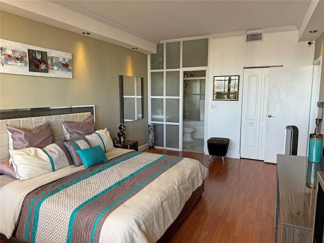 bedroom with crown molding, ensuite bath, a closet, and dark hardwood / wood-style flooring