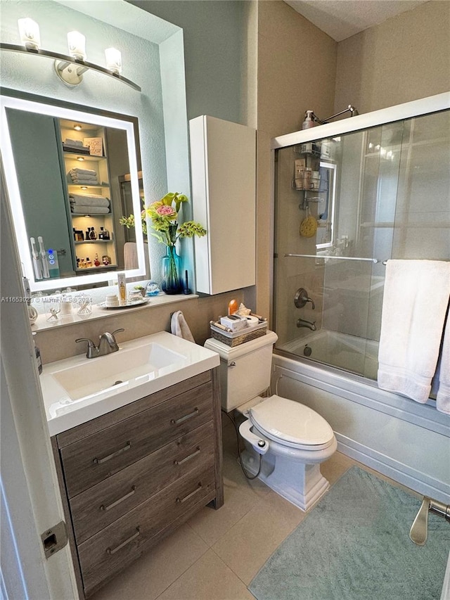 full bathroom with tile patterned flooring, vanity, toilet, and combined bath / shower with glass door