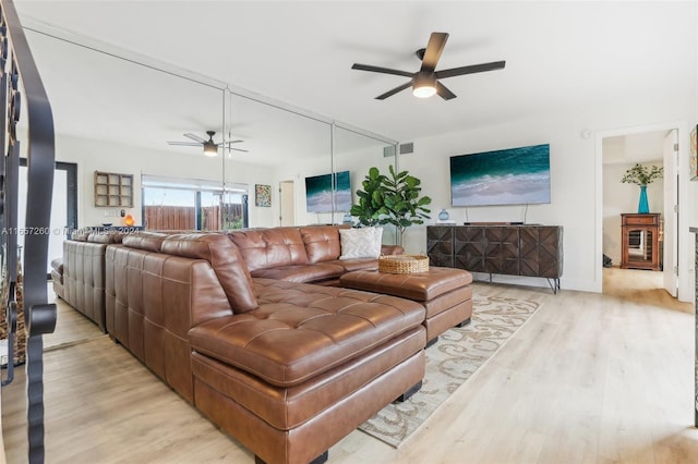 living room with light wood-type flooring and ceiling fan