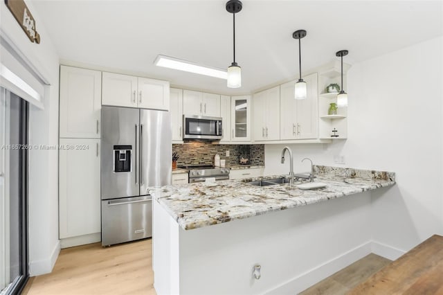 kitchen featuring white cabinetry, appliances with stainless steel finishes, sink, and kitchen peninsula