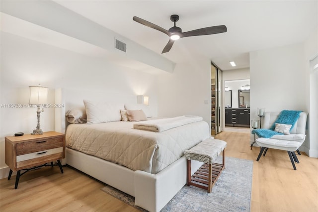 bedroom with a closet, ceiling fan, a spacious closet, and light hardwood / wood-style flooring