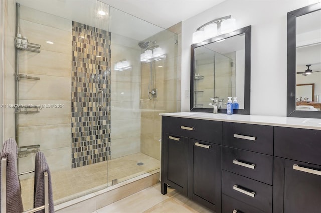 bathroom with a shower with door, vanity, ceiling fan, and tile patterned floors