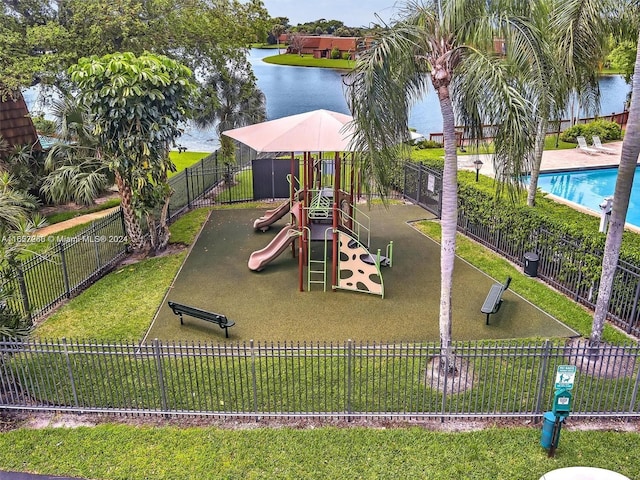 view of jungle gym featuring a water view, a community pool, and a yard