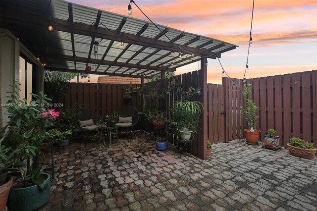 patio terrace at dusk featuring a pergola