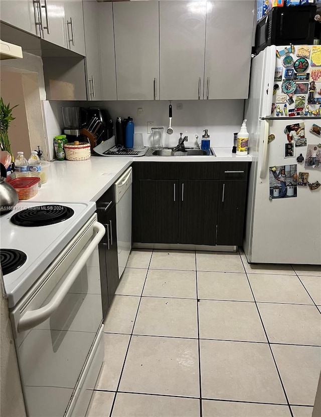 kitchen with white cabinets, white appliances, light tile patterned floors, and sink