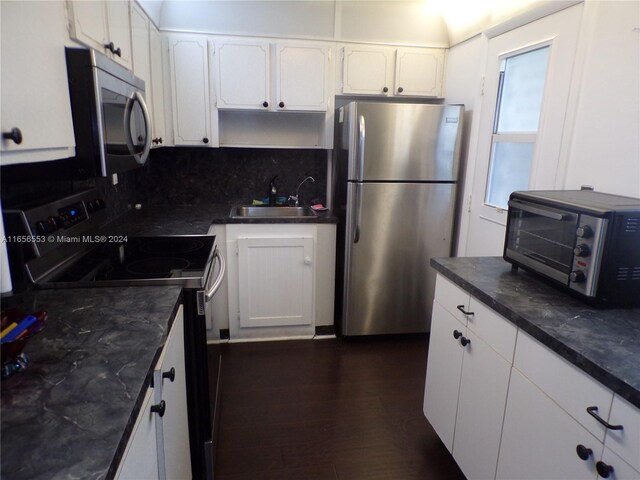 kitchen featuring stainless steel appliances, dark hardwood / wood-style flooring, white cabinetry, sink, and tasteful backsplash