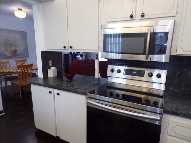 kitchen featuring dark stone counters, tasteful backsplash, stainless steel appliances, dark hardwood / wood-style floors, and white cabinets