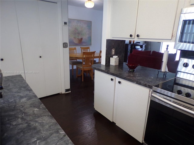 kitchen with dark wood-type flooring, stainless steel appliances, and white cabinetry