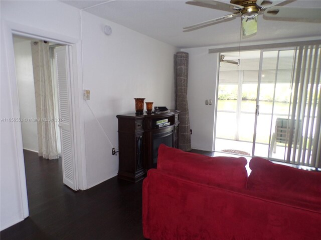 living room with dark hardwood / wood-style flooring and ceiling fan