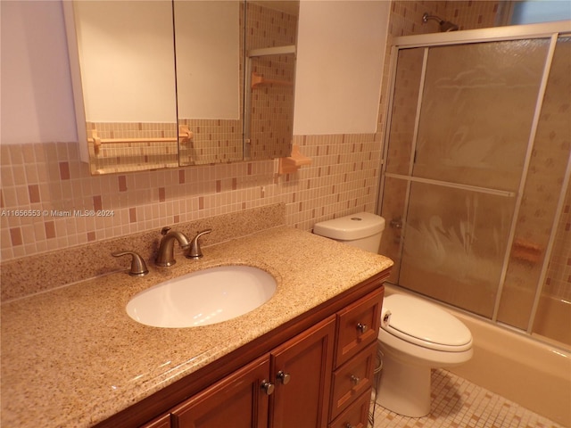 full bathroom with toilet, combined bath / shower with glass door, tile walls, tasteful backsplash, and vanity