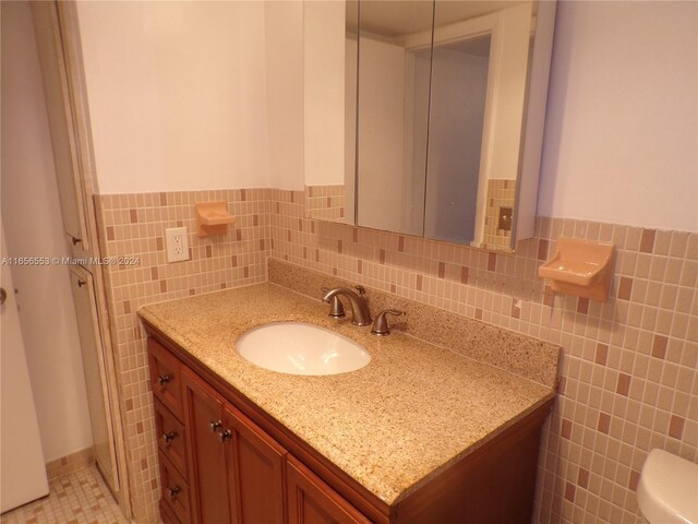 bathroom featuring tile walls, toilet, tasteful backsplash, and vanity