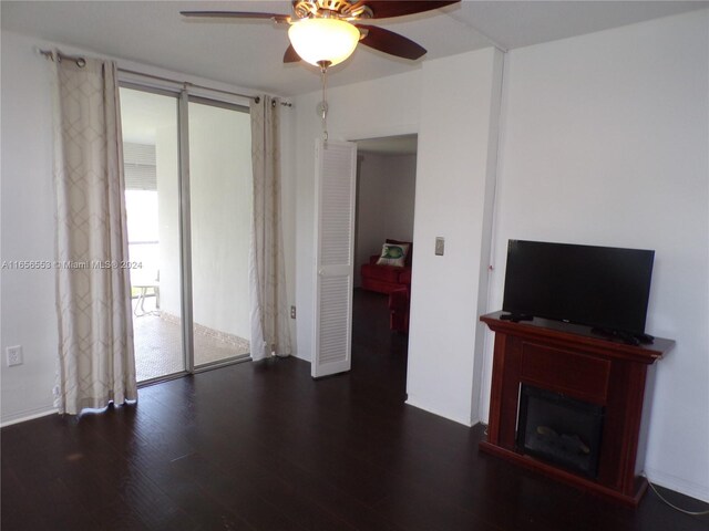 unfurnished living room featuring ceiling fan and dark hardwood / wood-style floors