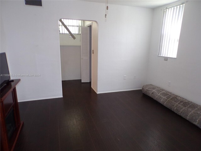 unfurnished room with dark wood-type flooring