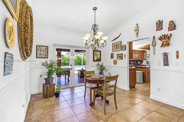 dining space with ornamental molding, an inviting chandelier, and french doors