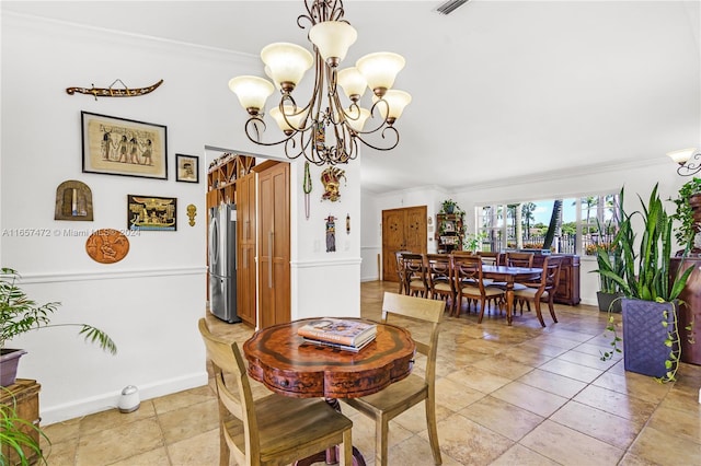 dining space with crown molding and a chandelier