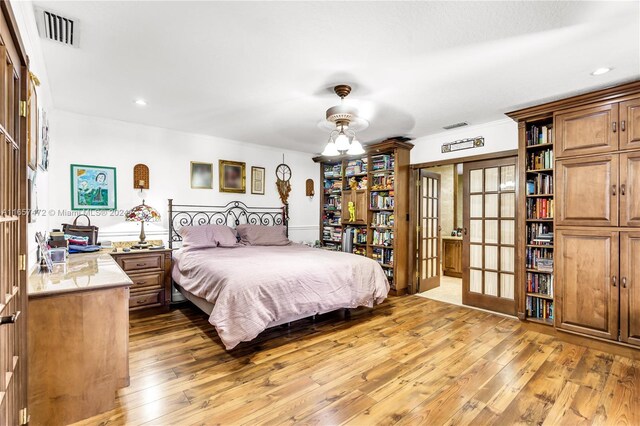 bedroom featuring french doors, hardwood / wood-style floors, and ceiling fan