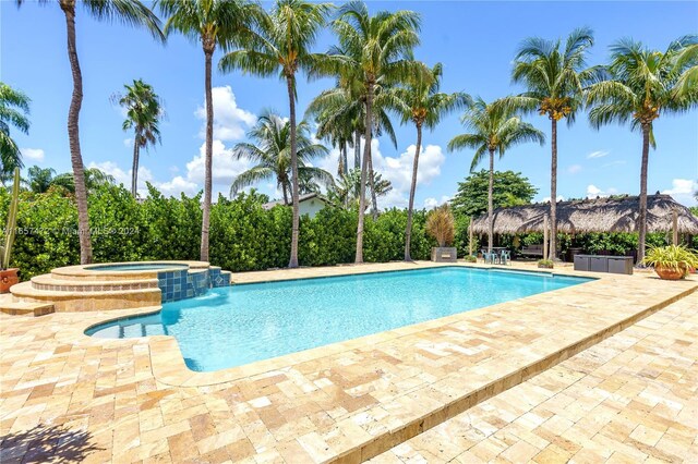 view of pool featuring a patio area and an in ground hot tub