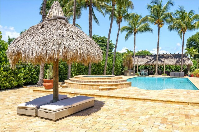 view of pool featuring a patio and an in ground hot tub