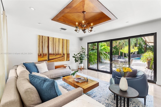 living room with plenty of natural light, wood-type flooring, and an inviting chandelier