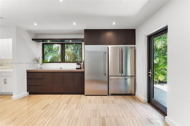 kitchen featuring dark brown cabinets and high end fridge