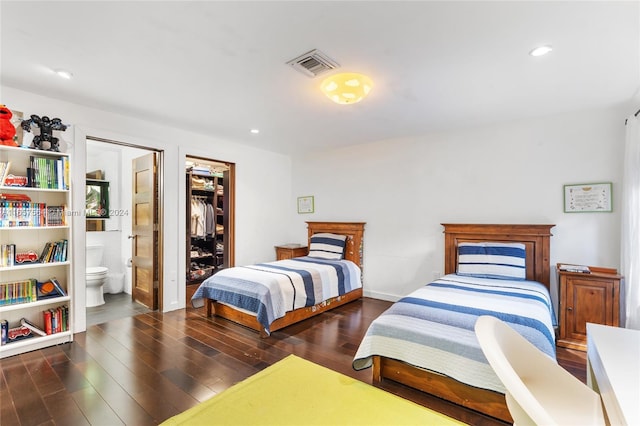 bedroom with a closet, ensuite bathroom, and dark hardwood / wood-style flooring