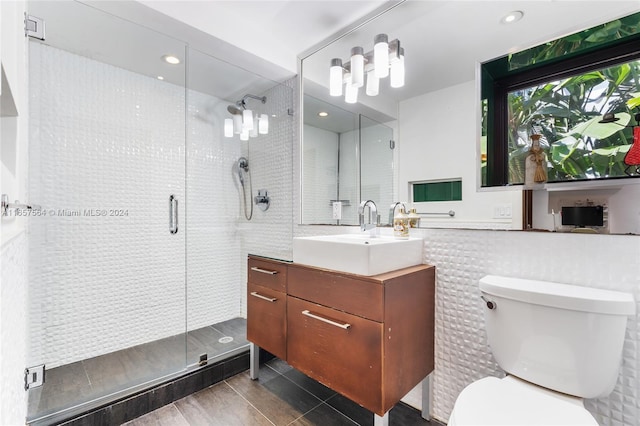 bathroom with hardwood / wood-style flooring, vanity, a shower with shower door, and toilet