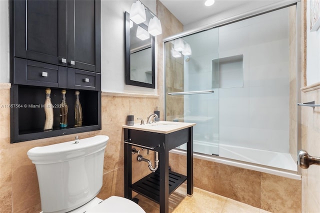 full bathroom featuring tile patterned flooring, enclosed tub / shower combo, toilet, vanity, and tile walls