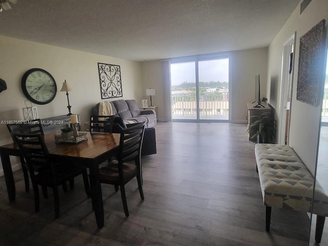 dining area with dark hardwood / wood-style flooring and a textured ceiling