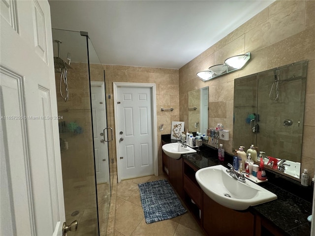 bathroom with vanity, tile walls, a shower with shower door, and tile patterned flooring