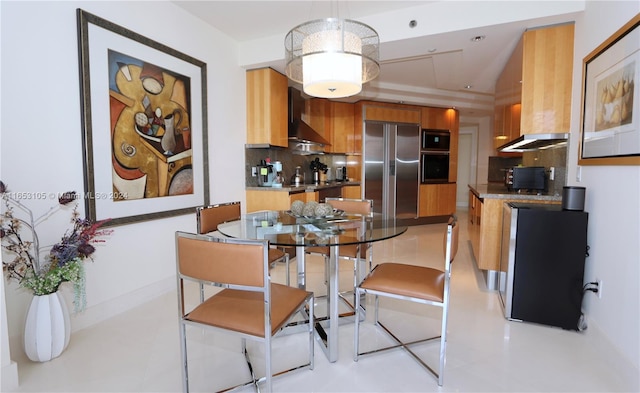 kitchen featuring built in appliances, backsplash, and wall chimney exhaust hood