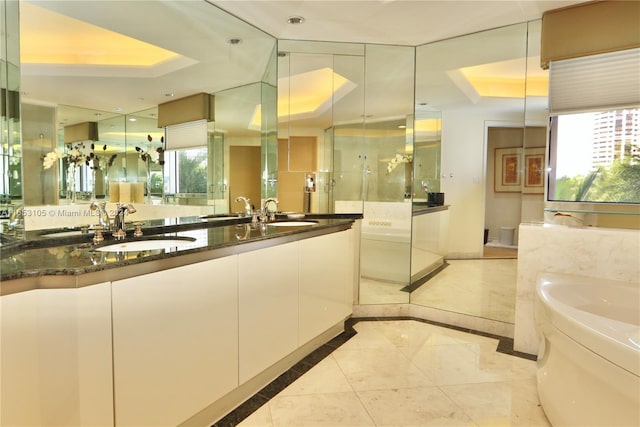 bathroom featuring a raised ceiling, plus walk in shower, and vanity