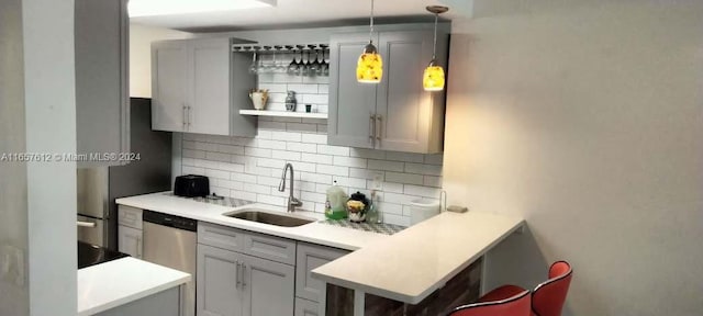 kitchen with gray cabinets, tasteful backsplash, sink, hanging light fixtures, and stainless steel dishwasher