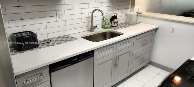 kitchen with decorative backsplash, stainless steel dishwasher, gray cabinetry, and sink