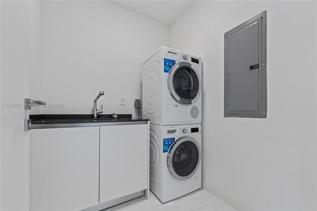 laundry room featuring stacked washer / dryer, sink, electric panel, and cabinets