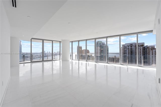 empty room featuring a water view and floor to ceiling windows