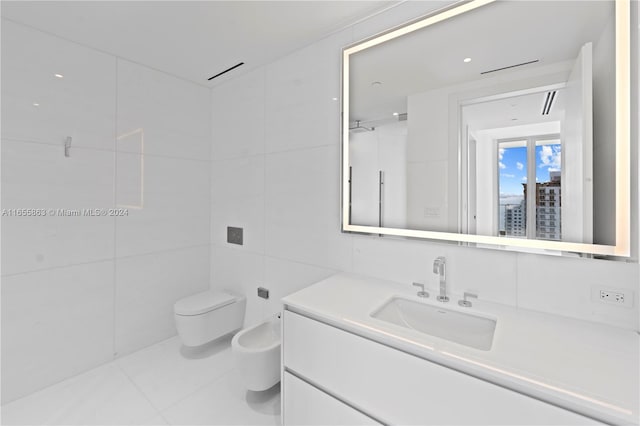 bathroom featuring tile patterned flooring, toilet, tile walls, a bidet, and vanity