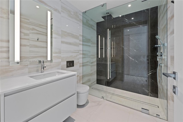 bathroom with a shower with door, vanity, toilet, and tile walls