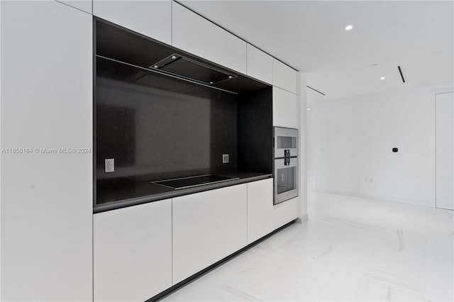 kitchen featuring white cabinets, black electric cooktop, and stainless steel double oven