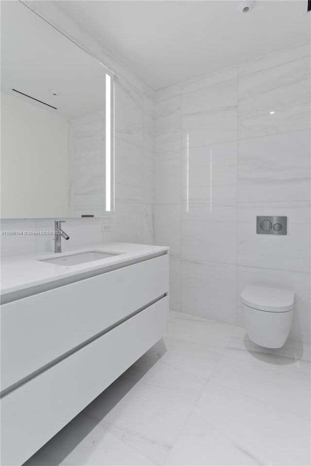 bathroom featuring vanity, toilet, and tile walls